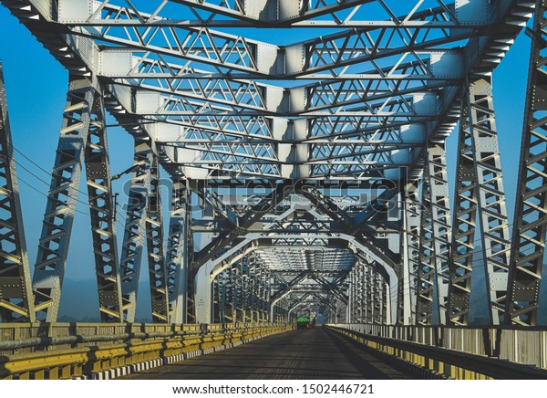 Metal\
bridge  over asphalt road, national highway,\
Assam