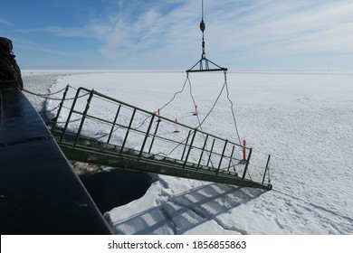 The Metal Bridge Spanned From The Icebreaker Parked In The Snow Sea So That People Can Walk Down To The Snow Below