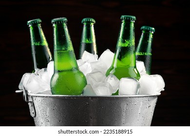 Metal bucket with bottles of beer and ice cubes on dark background, closeup - Powered by Shutterstock