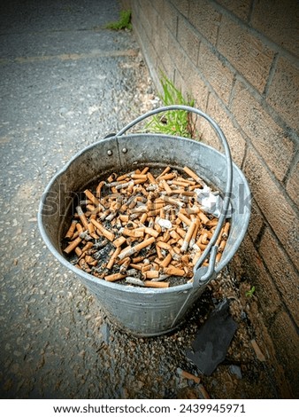 Metal bucket full of Cigarette stubs. new law in UK will make it illegal to sell cigarettes to anyone born after January 1st 2009.