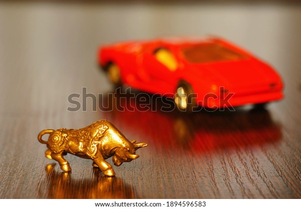 Metal\
bull on the table. In the background is a toy\
car.