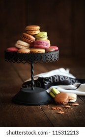 Metal Cake Stand With Macaroons On Dark Wood Background