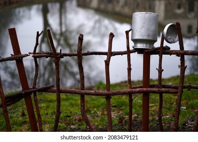 Metal can on the fence. Rural landscapes, traditional old clay pots on a wicker fence. metal milk container on the fence, a village tradition.