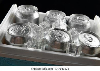 Metal Cans Of Beer With Ice Cubes In Mini Refrigerator, Close Up