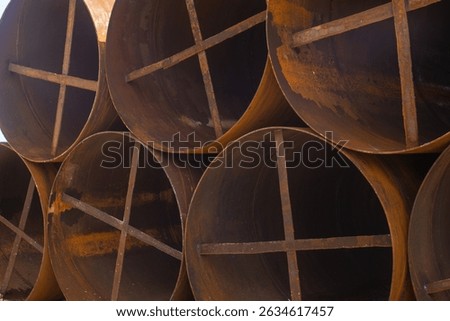 metal casing pipes of large diameter, stacked.  They are used in bridge construction, in particular, for drilling piles in difficult geological conditions, including underwater drilling
