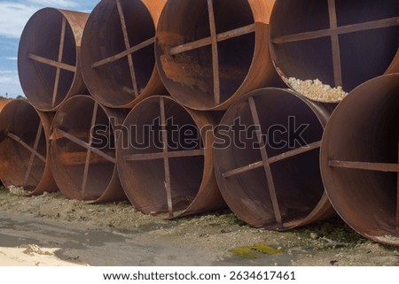 metal casing pipes of large diameter, stacked.  They are used in bridge construction, in particular, for drilling piles in difficult geological conditions, including underwater drilling