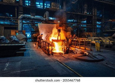 Metal cast process in blast furnace in metallurgical plant or factory. Liquid iron molten metal pouring in container, heavy industry background - Shutterstock ID 2055467768