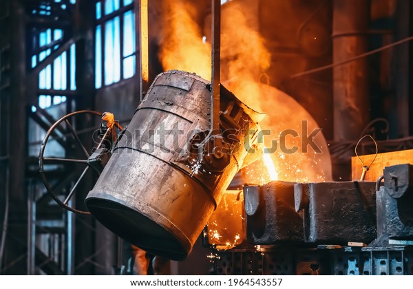 Metal casting process in foundry, liquid metal\
pouring from container to mold with clubs of steam and sparks,\
heavy metallurgy industry\
background
