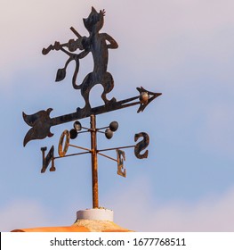 Metal Cat With A Fiddle Weather Vane On A Roof