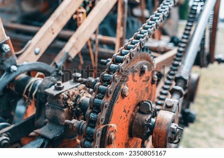 Metal chain on large gears on an old combine