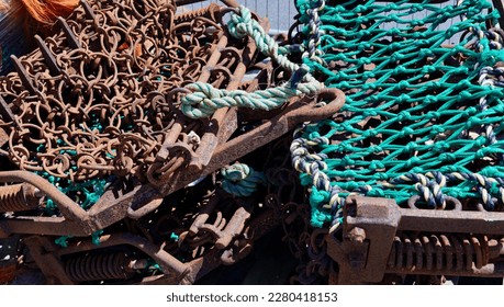 Metal chains and nets for use by fishing trawlers stacked on dockside with chains