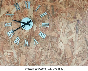 Metal Clock Stuck On A Wooden Wall.