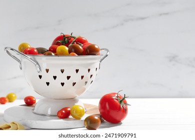 Metal colander with fresh tomatoes on white wooden table, space for text - Powered by Shutterstock