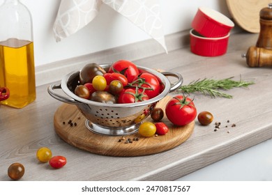 Metal colander with tomatoes on countertop in kitchen - Powered by Shutterstock