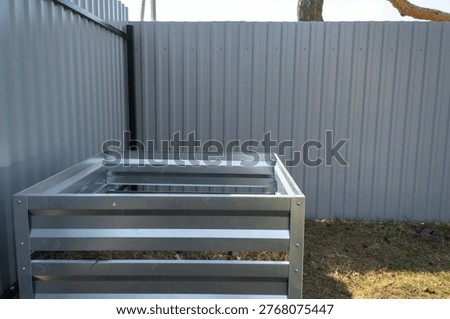 Metal compost bin frame, preparation for collecting compost from food scraps and grass, eco garden waste recycling, sustainable gardening setup.