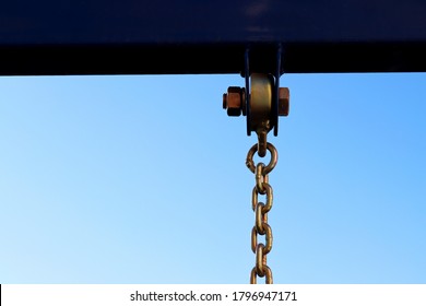 Metal Construction With Bolt And Iron Shiny Thick Chain Against The Blue Sky . Metal Chain Of A Swing Set Seat In Soft High Key Focus