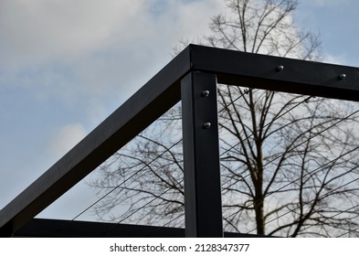 metal construction of the bus stop, gazebo pergola shelter. the roof and walls are braided with a rope net for climbing plants. is anchored with stainless steel couplings. black block-shaped tunnel,