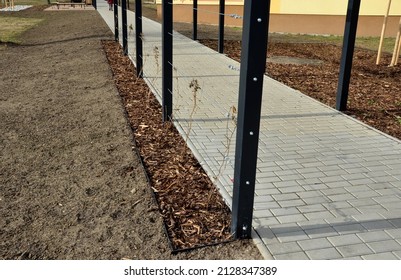 metal construction of the bus stop, gazebo pergola shelter. the roof and walls are braided with a rope net for climbing plants. is anchored with stainless steel couplings. black block-shaped tunnel,