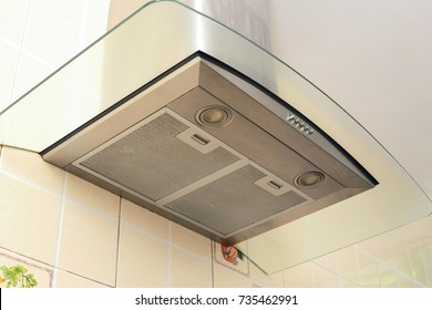 Metal cooker hood extractor fan with spotlight in luxury kitchen.