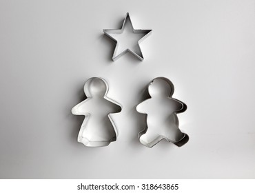 Metal Cookie Cutter Of Gingerbread Man, Woman And A Star On A White Kitchen Top.