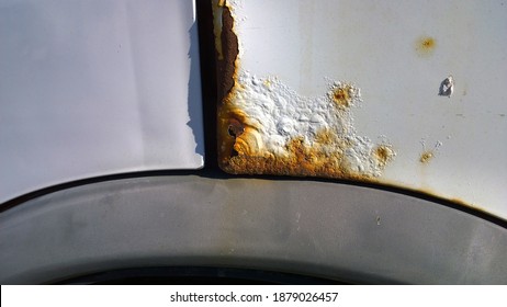 Metal Corrosion Of Old Car. Rust Hole Removal And Repair. Rusty Messy Surface. Damaged Grunge Texture From Road Salt. Paint Vehicle. Service. Wheel Well And Rocker Panel. Protecting Automobile Concept