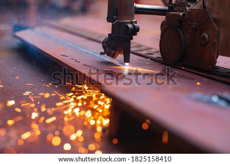Metal cutting spark on tank bottom steel plate with flash of cutting light close up in side confined space.