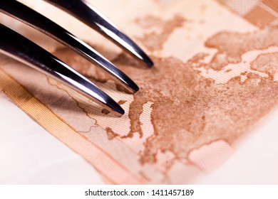 Metal Dessert Fork Points To The Map Of The European Union On A Banknote Of 50 Euros. The Concept Of Immigration Crisis