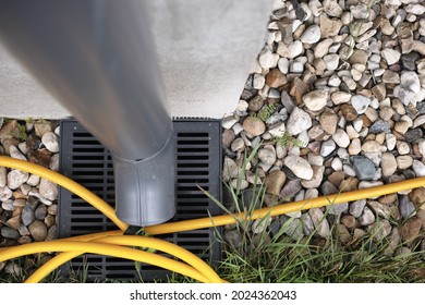 A Metal Downspout, Water Hose And Gravel, Above View