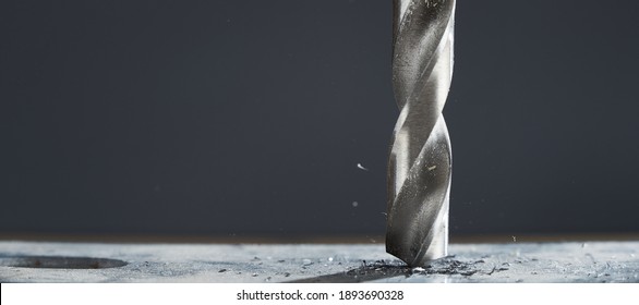 Metal drill bit make holes in metal billet on industrial drilling machine with shavings. - Powered by Shutterstock