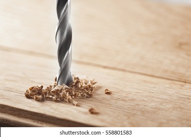 metal drill bit make holes in a wooden oaks plank