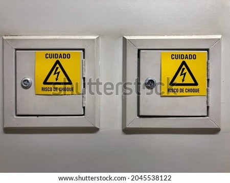 Metal energy boxes. Written in Portuguese: Caution - Risk of shock.
