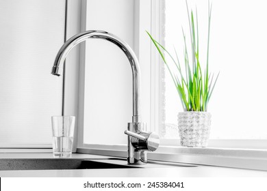 Metal faucet in a kitchen - Shutterstock ID 245384041