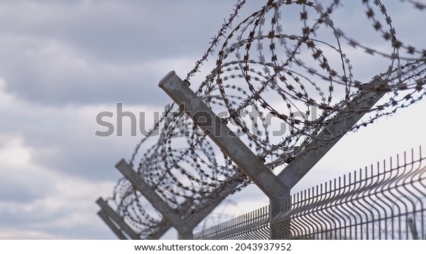 Metal Fence\
with Barbed Wire Securing Restricted Area Military Zone Border\
during Refugee Humanitarian\
Crisis