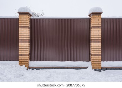 Metal Fence By The Village House At Winter Time.