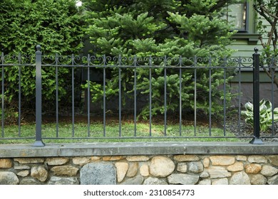Metal fence symbolizes boundaries, security, protection, privacy, and delineates spaces with its strong and sturdy presence - Shutterstock ID 2310854773