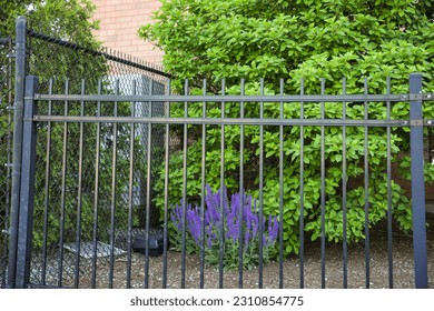 Metal fence symbolizes boundaries, security, protection, privacy, and delineates spaces with its strong and sturdy presence - Shutterstock ID 2310854775