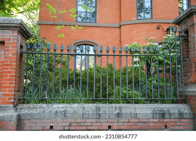 Metal fence symbolizes boundaries, security, protection, privacy, and delineates spaces with its strong and sturdy presence - Shutterstock ID 2310854777