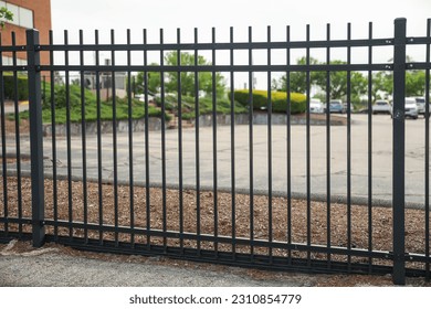 Metal fence symbolizes boundaries, security, protection, privacy, and delineates spaces with its strong and sturdy presence - Shutterstock ID 2310854779