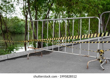 Metal Fence And Yellow Black Safety Tape Green Trees And River Flood Danger Emergency 