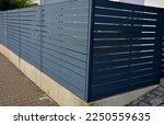 metal fillings of fence with an underlay of concrete blocks. A metal aluminum fence will provide privacy around the garden. horizontal slats cover well. a hedge made of tuji adds protection, concrete