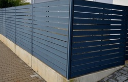 Metal Fillings Of Fence With An Underlay Of Concrete Blocks. A Metal Aluminum Fence Will Provide Privacy Around The Garden. Horizontal Slats Cover Well. A Hedge Made Of Tuji Adds Protection, Concrete