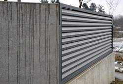 Metal Fillings Of Fence With An Underlay Of Concrete Blocks. A Metal Aluminum Fence Will Provide Privacy Around The Garden. Horizontal Slats Cover Well. A Hedge Made Of Aluminium Protection, Concrete