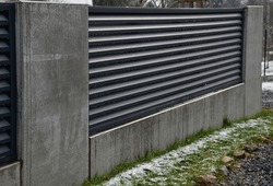 Metal Fillings Of Fence With An Underlay Of Concrete Blocks. A Metal Aluminum Fence Will Provide Privacy Around The Garden. Horizontal Slats Cover Well. A Hedge Made Of Aluminium Protection, Concrete