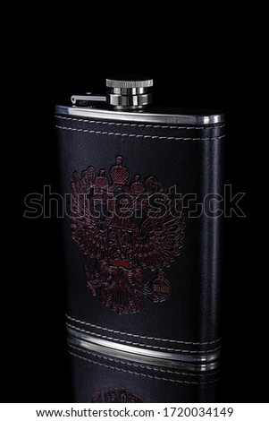 Metal flask in a leather case with a pattern depicting a doubleheaded eagle on a black background