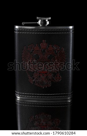 Metal flask in a leather case with a pattern depicting a doubleheaded eagle on a black background