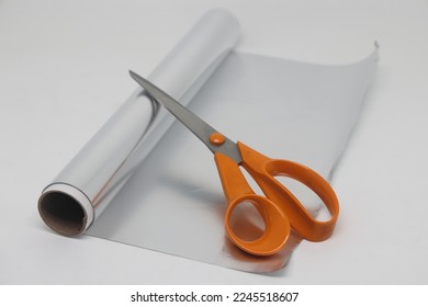 Metal food foil cut into strips and scissors. For sharpening scissors in everyday life