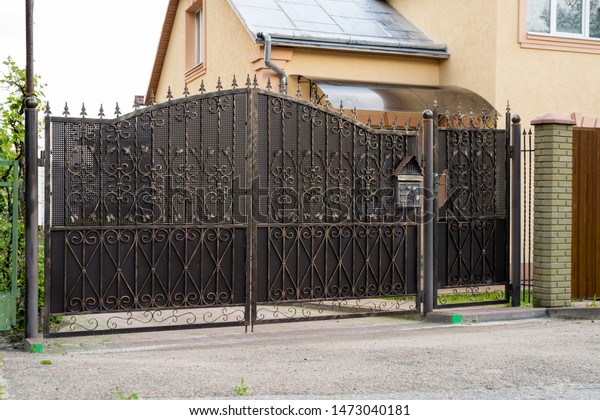 Metal forged gates with a gate for cars to enter\
the courtyard and\
security