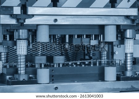 The metal forming process by progressive die in the light blue scene. The metal stamping equipment for manufacturing process.