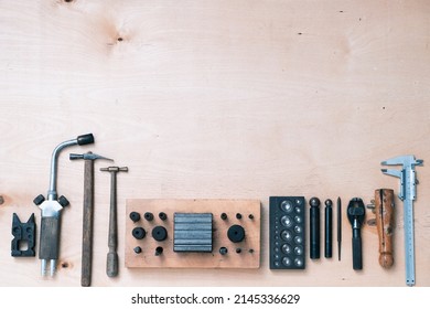 Metal forming tools on the table in a goldsmith's workshop. Top view, flat lay. - Powered by Shutterstock