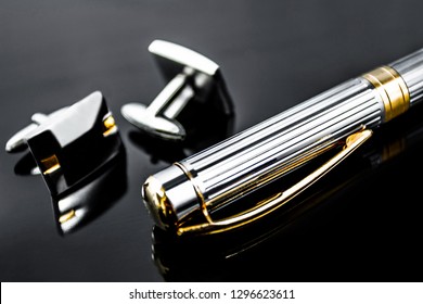 Metal fountain pen with men's luxury cufflinks on a black isolated background. Conceptual male dilovy style, business project